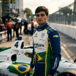 Caio Collet in AJ Foyt Racing IndyCar suit standing next to number 4 Chevrolet with Combitrans Amazonia sponsorship representing Brazil