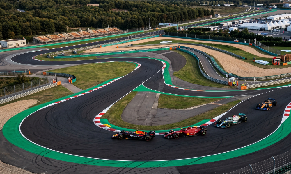 Aerial view of Istanbul Park circuit with F1 cars racing through Turn 8 at sunset