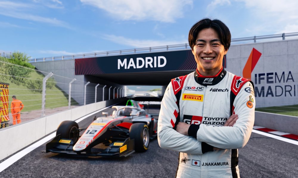 "A portrait of smiling Japanese F3 driver J. Nakamura at the IFEMA Madrid street circuit, standing near his #12 race car with clear visible 'MADRID' and 'IFEMA MADRID' branding."