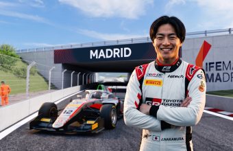 "A portrait of smiling Japanese F3 driver J. Nakamura at the IFEMA Madrid street circuit, standing near his #12 race car with clear visible 'MADRID' and 'IFEMA MADRID' branding."