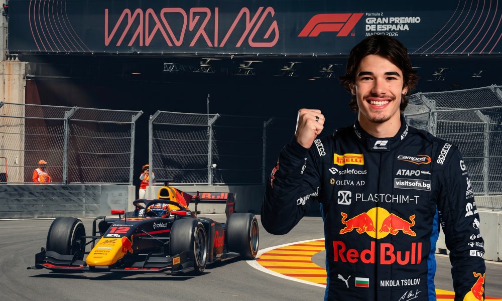 "Portrait of smiling Bulgarian F2 driver Nikola Tsolov in his Red Bull suit, fist raised, standing near his #12 F2 car at the IFEMA Madrid street circuit."